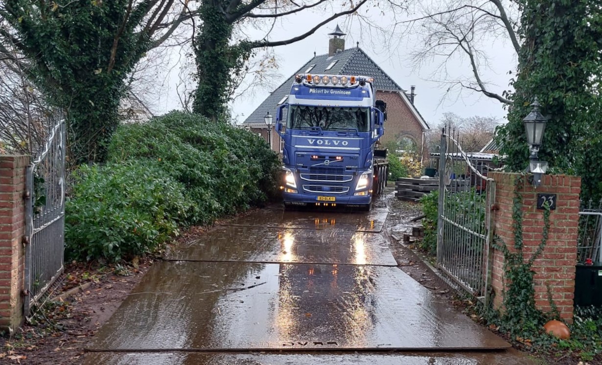 Een vrachtauto rijdt over staken rijplaten