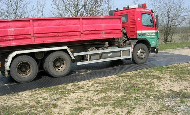 Vrachtwagen rijdt over kunststof rijplaten